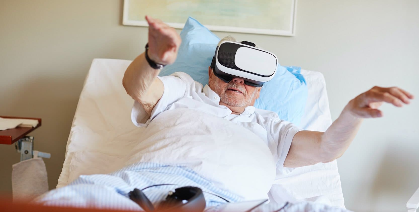 Man i vårdsäng med VR-glasögon.